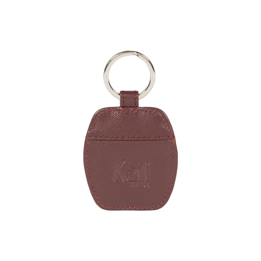 K10854XB | Genuine Saffiano Leather Keyring. Bordeaux color. Polished Nickel key ring. Total dimensions: 5.5 x 9.5 x 0.5 cm. Packaging: Rigid bottom/lid gift box