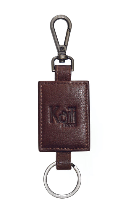 K10650BB | Keychain in Genuine Full Grain Leather, Flywheel. Color dark brown. Antique Nickel Accessories. Total dimensions: 4 x 15 x 0.5 cm. Packaging: Rigid bottom/lid gift box